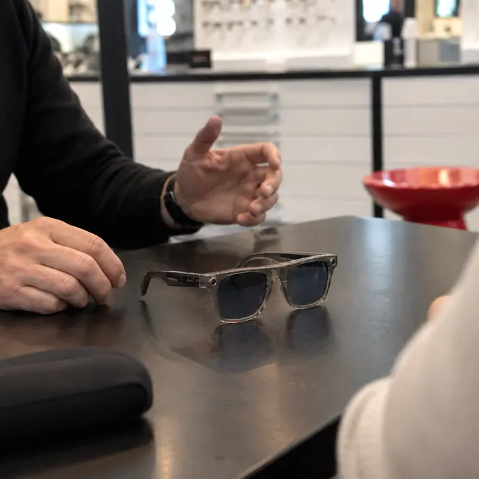 Opticien qui conseille un client avant d'acheter des lunettes connectées